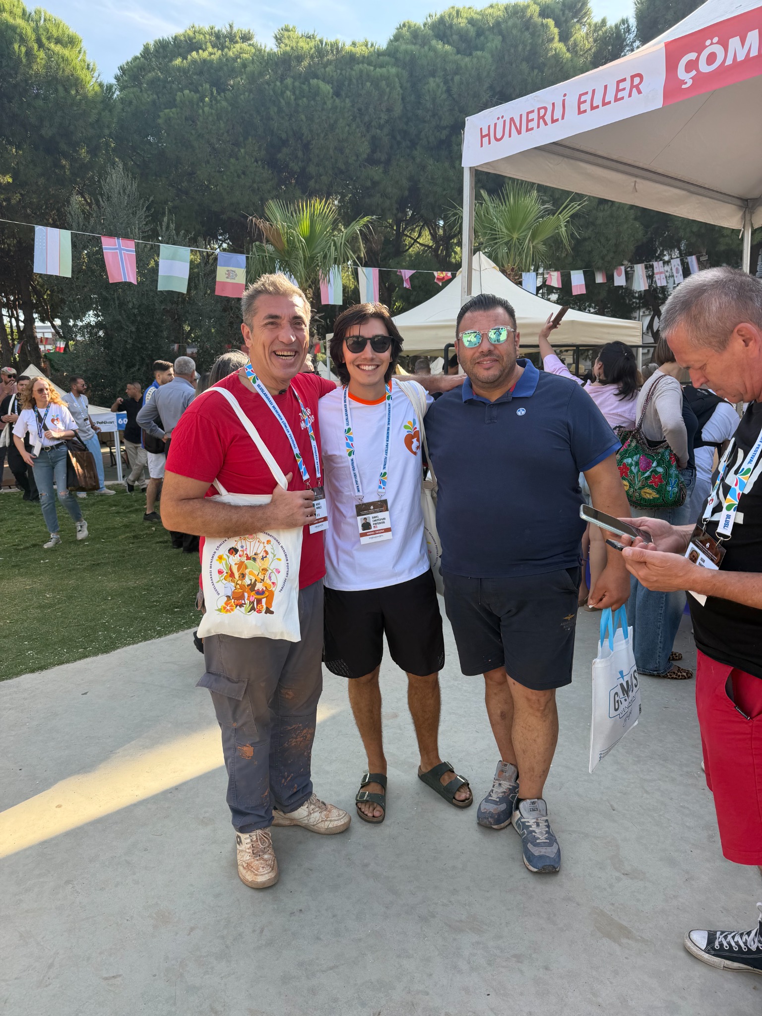 Daniel with two festival participants beneath rows of international flags