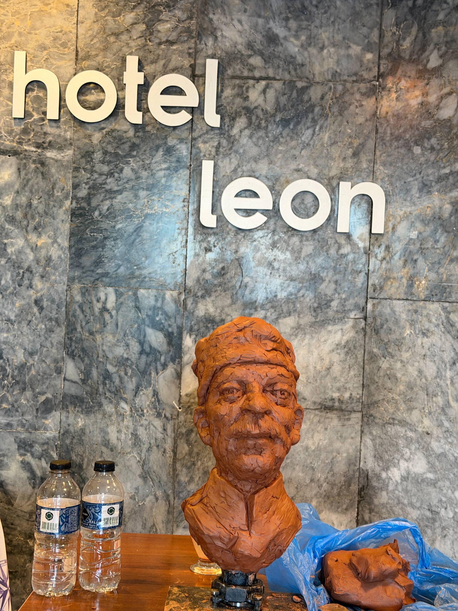 Expressive clay portrait bust displayed on a worktable