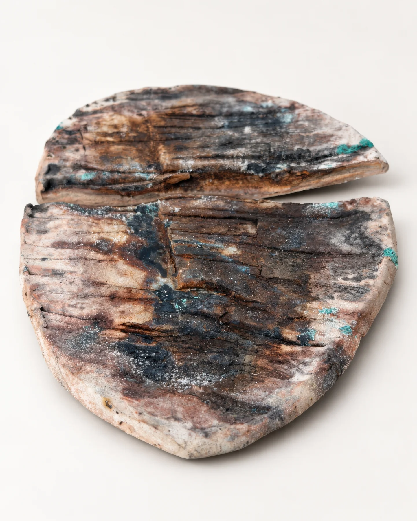 Saggar Piece 2: a ceramic piece broken in two, with teal glaze marks.